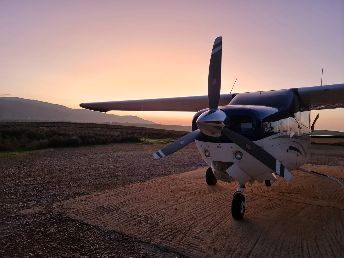 Cessna van Africa Sky Runners op een afgelegen airstrip ergens in Afrika met tegenlicht van de ondergaande zon