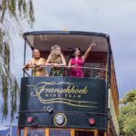 Drie jonge vrouwen op het balkon van de Franschhoek wijntram